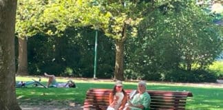 To ældre personer på en bænk i en park.
