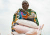 A woman carries sacks of seeds distributed to families in South Sudan during the COVID-19 pandemic.