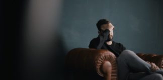 Man sitting on sofa | Photo by Nik Shuliahin on Unsplash