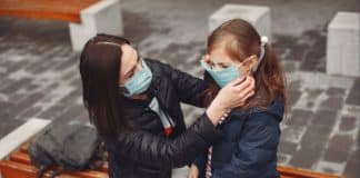Mother helping put her mask on