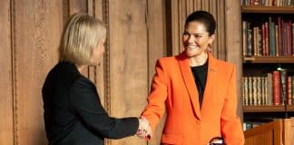 Two women shaking hands in a formal setting