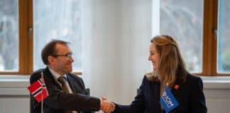 A man and a woman shaking hands in a formal setting