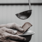 adding soup to a bowl held by an elderly person