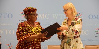 Two women in an official setting sharing documents