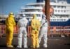 Workers in hazmat suits waiting at docks