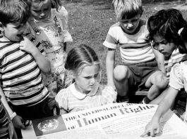 Niños miran un póster de la Declaración Universal de los Derechos Humanos