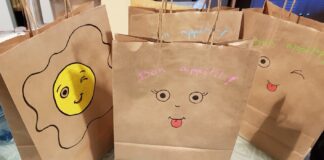 Sac en kraft contenant des paniers repas, illustré avec des yeux et des sourires