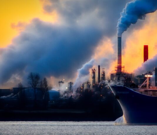 fumées qui se dégagent de cheminées d'usines au coucher du soleil