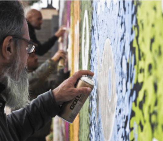 Graffeurs en train de réaliser une fresque murale