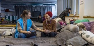 une représentante du HCR parle avec une vieille dame ukrainienne refugiée en Pologne.