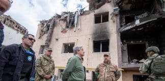 Antonio Guterres en visite en Ukraine devant des batiments démolis
