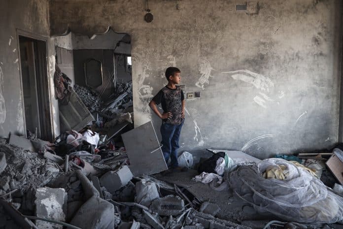 Un jeune garçon dans un immeuble détruit à Gaza. des rapporteurs de l'ONU craignent un génocide.