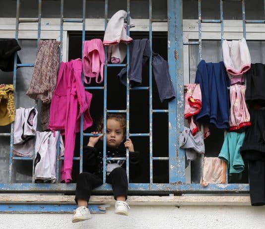 Un enfant derrière un balcon dans l'une des écoles de l'UNRWA qui sert d'abri aux déplacés dans la bande de Gaza.