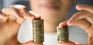 Une femme tenant deux piles de pièces de monnaies de tailles différentes