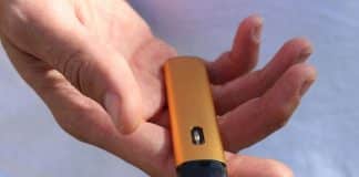 Cigarette électronique jetable jaune dans une main.
