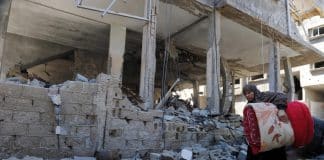 Une résidente palestinienne marche derrière un bâtiment détruit par les frappes aériennes israéliennes à Gaza. Les violences basées sur le genre touchent les femmes et les filles de manière disproportionnée.