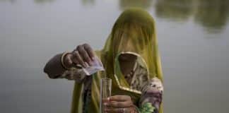 Une jeune femme teste de l'eau dans un étand en INde pour vérifier sa qualité.