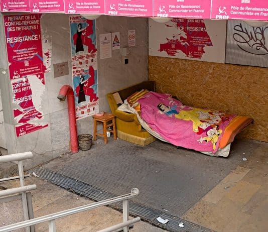 Lit d'un sans abri avec couverture rose Disney dans la rue
