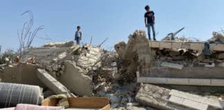 Des enfants se tiennent sur une maison démolie à Beit Sira, un village palestinien situé au centre de la Cisjordanie