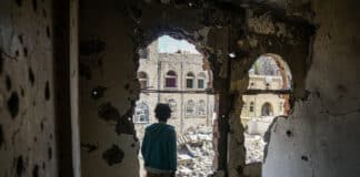 Un garçon se tient dans l’intérieur endommagé d’un bâtiment près de la ligne de front active à Taïz, au Yémen