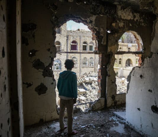 Un garçon se tient dans l’intérieur endommagé d’un bâtiment près de la ligne de front active à Taïz, au Yémen