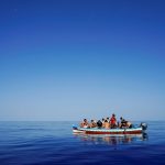 rifugiati e migranti alla deriva in una barca di legno aspettano di essere salvati vicino all'isola italiana di Lampedusa nel Mar Mediterraneo