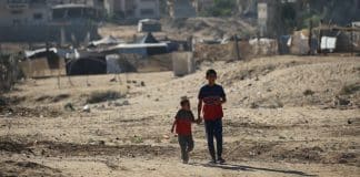 Due bambini camminano mano nella mano