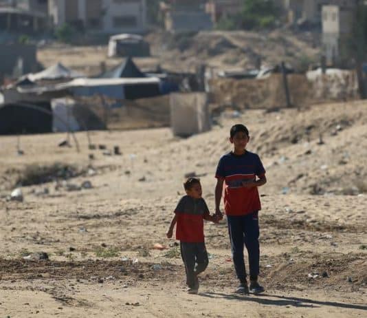 Due bambini camminano mano nella mano