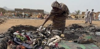 Una donna Sudanese cerca tra le macerie