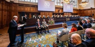 António Guterres spreekt tijdens de 80-jarige bijeenkomst van het Internationaal Gerechtshof in het Vredespaleis in Den Haag, met de rechters op de achtergrond.