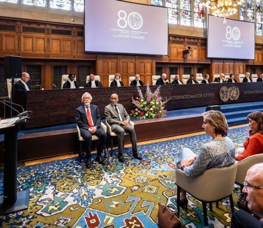 António Guterres spreekt tijdens de 80-jarige bijeenkomst van het Internationaal Gerechtshof in het Vredespaleis in Den Haag, met de rechters op de achtergrond.