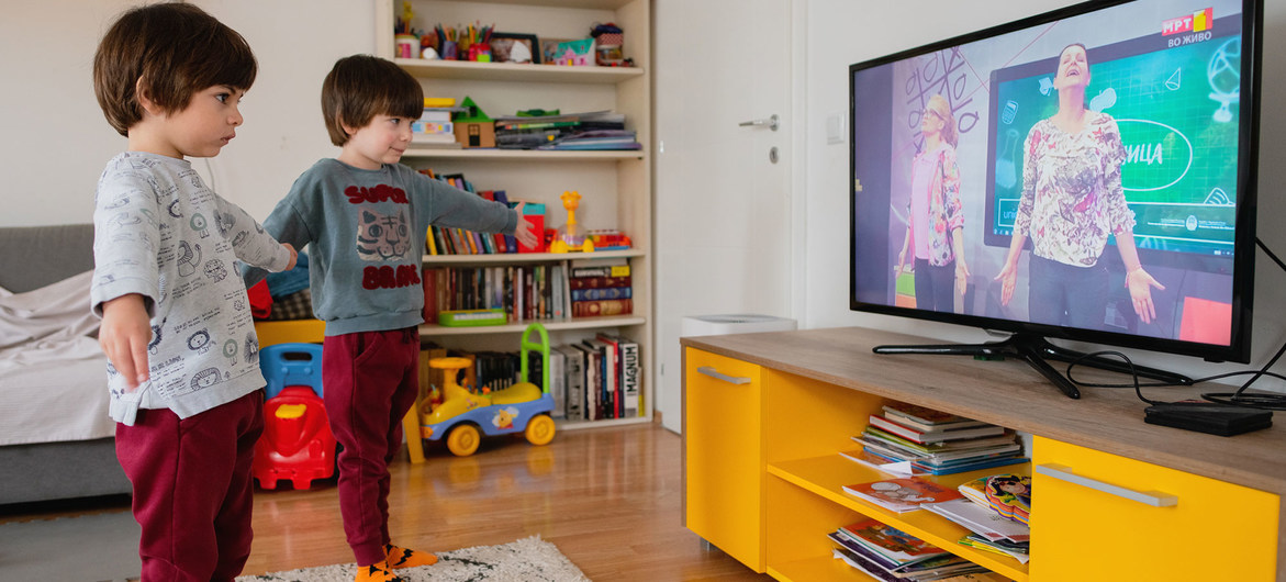 Irmãos gêmeos na Macedônia do Norte assistem a aula na TV