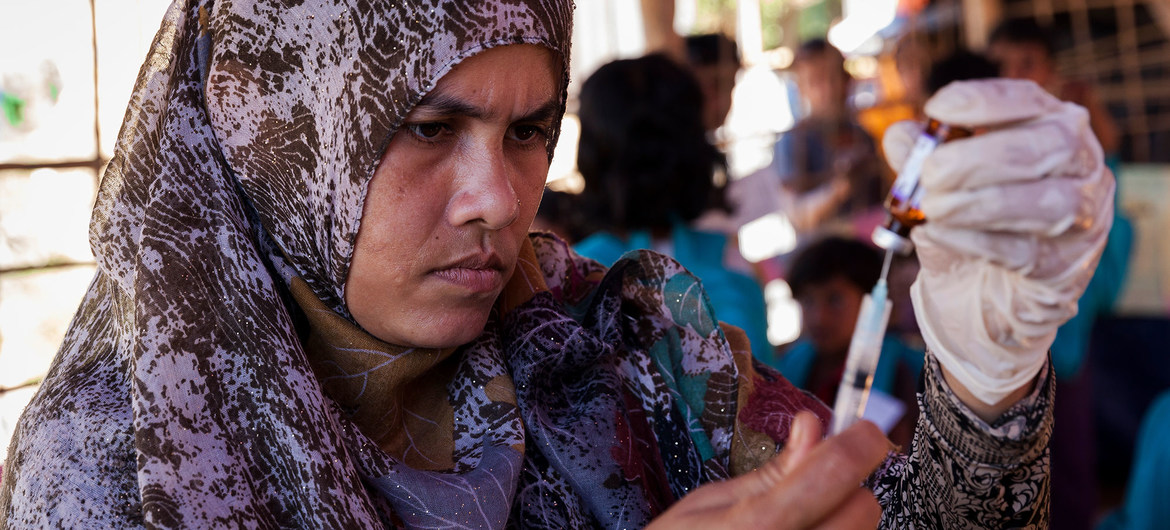 Funcionária de sáude prepara vacina em assentamento de refugiados rohingya em Bangladesh