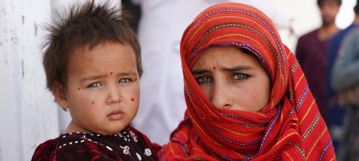 Menina de 12 anos segura a irmã em campo para deslocados internos em Herat, no Afeganistão