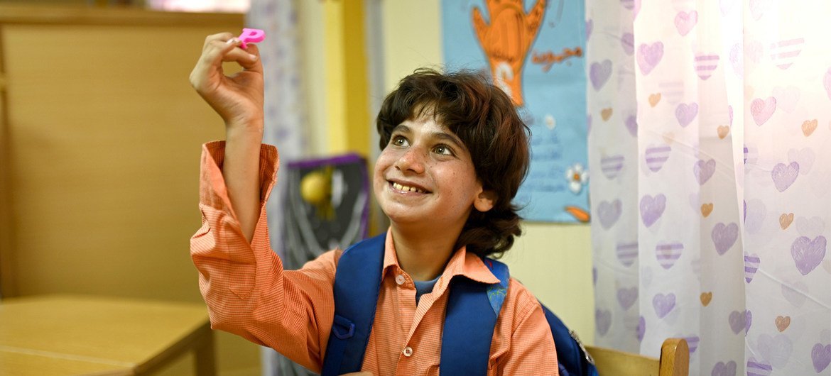 No Egito, Mahmoud, que tem autismo, participa de uma atividade com letras. 