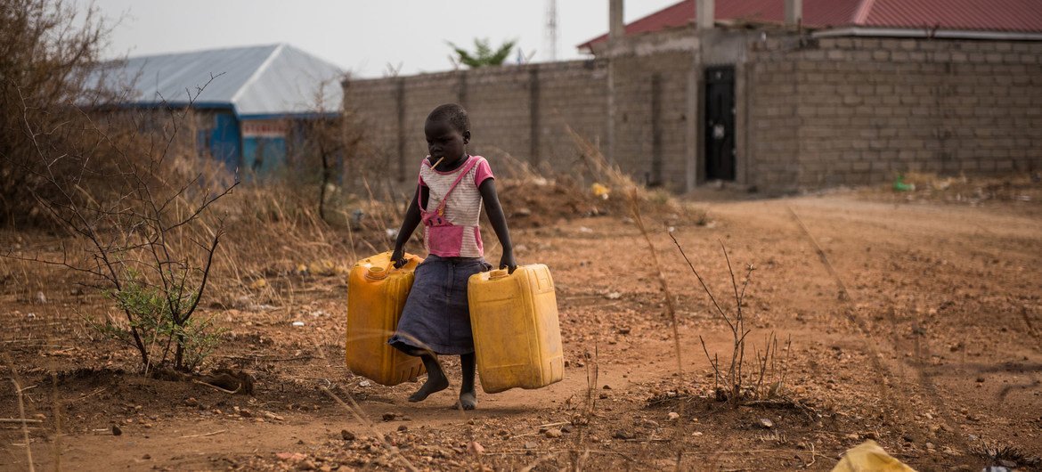 Uma criança carrega recipientes vazios para encher com água de uma torneira próxima, que fornece água não tratada do rio Nilo em Juba, Sudão do Sul