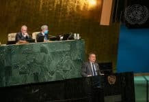 En man som talar vid en talarstol inför ett plenum