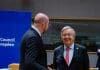Two men talking in an official setting, one is laughing