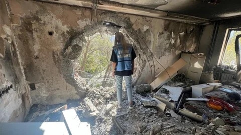 En person som står i ett sönderbombat hus